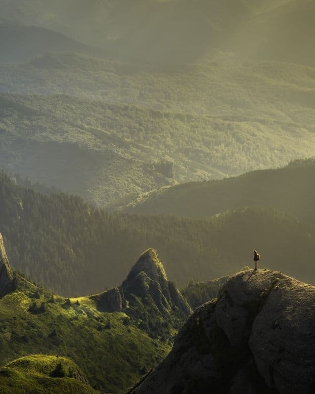 Viajero contemplando un paisaje de montaña al amanecer